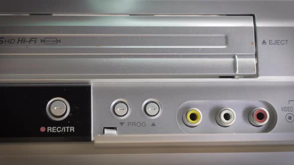 Closeup Shot of a Vintage Vhs Cassette Being Inserted Into a Cassette Player alt