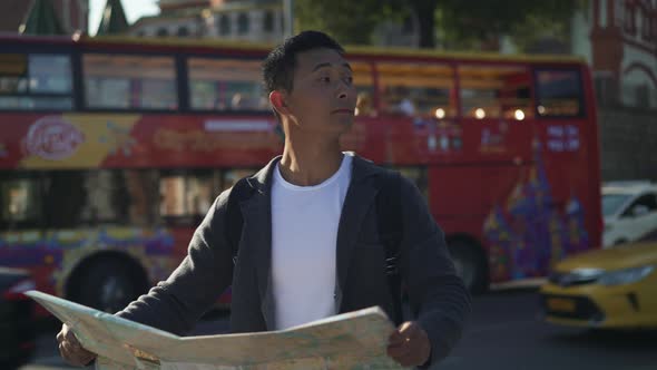 Real Time Shot of a Young Tourist Looking for Attractions in Moscow with a Map in His Hands. Moscow alt