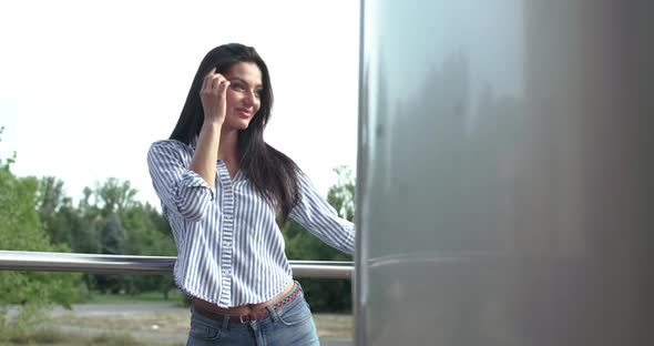 Attractive Lady Leaned on Stairs' Handrail, Corrects Hair and Rejoices Outdoor alt