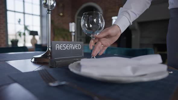 Male Hand Putting Drinking Glass on Table with Reserved Sign alt
