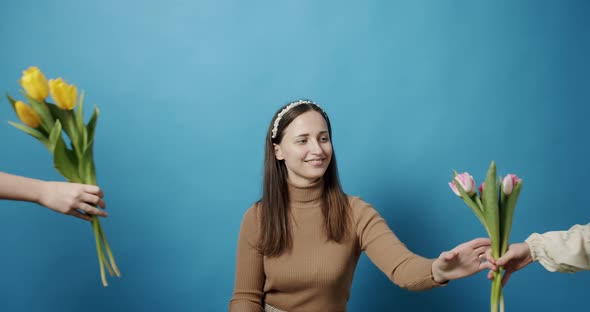 Sisters with Tulips Flowers Giving to Mom on a Blue Background Happy Mother alt