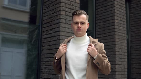 Stylish Male Businessman in Brown Coat Near Office Center Looking at the Camera alt