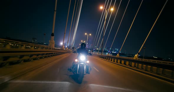 Motorcyclist Rides Motorbike on Bridge in Warsaw City Downtown at Night