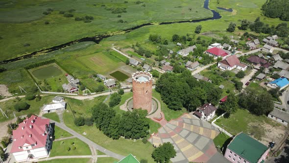 Flight Over A Provincial Town. An Ancient Tower Among The Multi Colored Roofs Of Houses alt