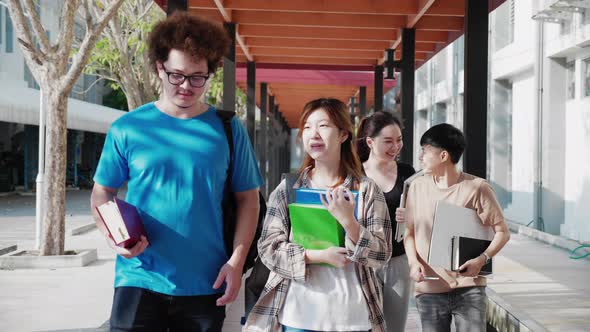 student teenagers walking on walkway of university after study off