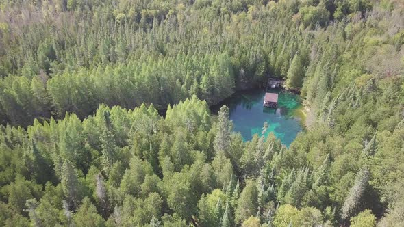 Aerial drone shot flying over crystal blue water of Kitch-iti-kipi, the big spring in Palms Book Sta alt