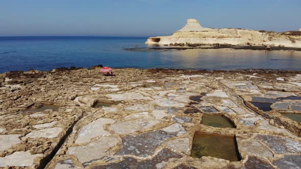 An aerial drone shot pans across rock-cut Salt Pans, Qbajjar Bay and Marsalforn on the island of Goz alt