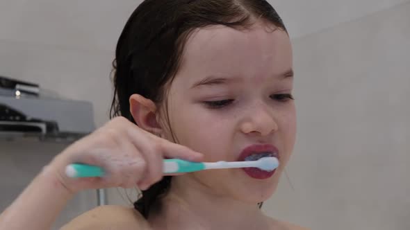 Little Girl Brushing Her Teeth in the Bathroom