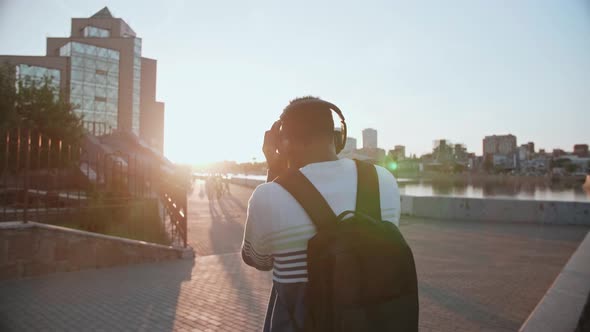 Black Student Walks Around Town at Sunset He's Happy