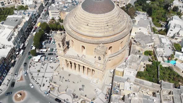 A far view, aerial 4k drone, footage tilt revealing the Mosta Rotunda Dome and the surrounding city alt