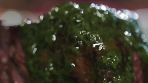 Close-up of Juicy beef steak filet mignon on plate is poured green herb sauce alt