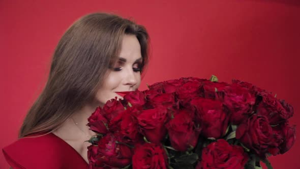 Gorgeous Woman in Red Dress Spinning with Bouquet of Roses