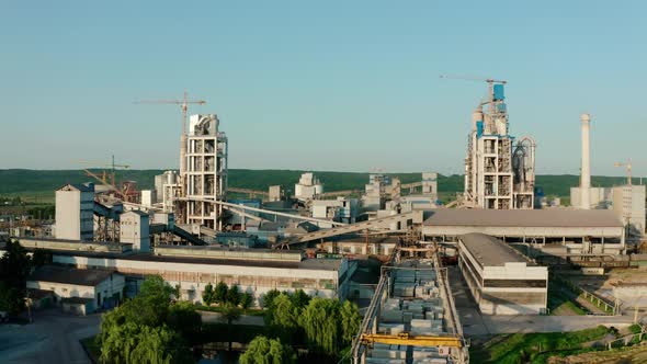 Cement Plant with High Factory Structure at Industrial Production Area at Sunset alt