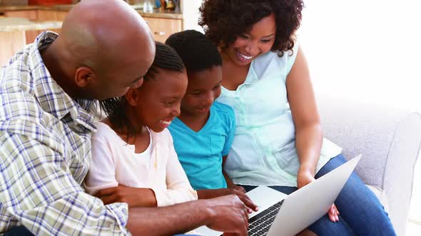Family using laptop in living room 4k alt