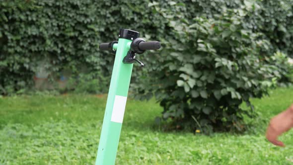 Man with Smartphone Riding Electric Scooter alt