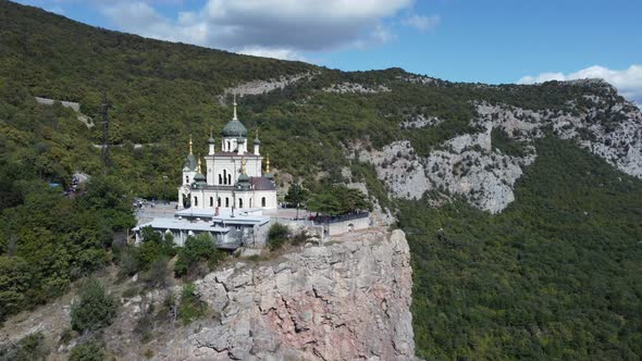Church at the edge of the cliff in mountains alt