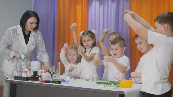 Chemical Experiments for Children. Children Holding in His Hand a Long Green Worms. Room Is Filled alt