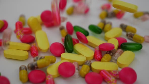 Micro shot of dropping different color tablets over a white background