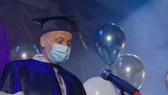 University Lecturers in Gown and Medical Mask are Solemnly Presenting Diplomas to Graduates Online alt