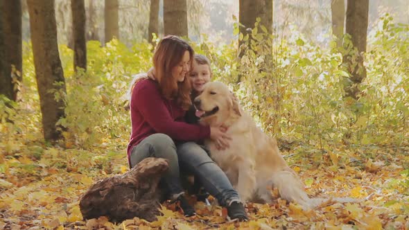 Mother And Son Playing With A Dog