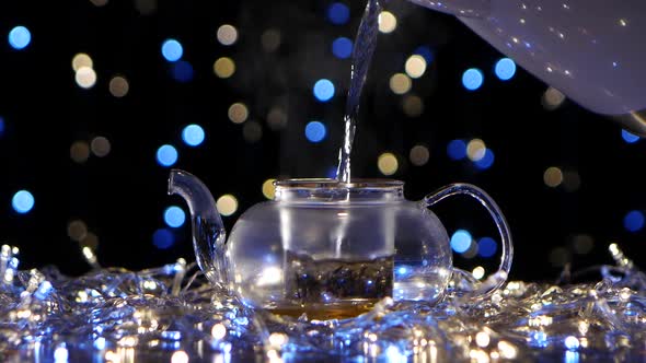 Boiling Water Pour in Teapot with Tea Leaves. Flickering Lights alt