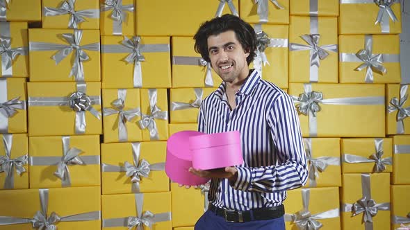 A Stylish Man Among a Lot of Gift Boxes with Gifts in His Hands Celebrates a Holiday an Excited