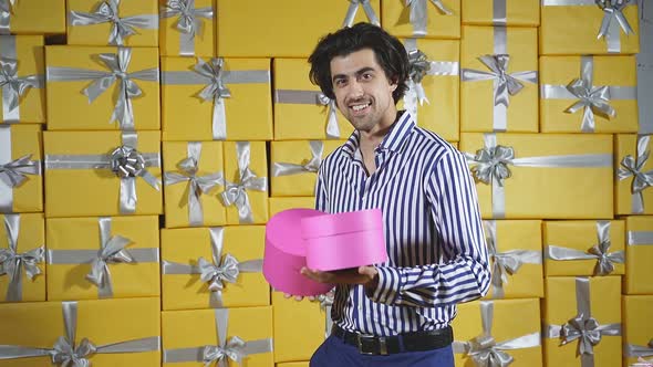 A Stylish Man Among a Lot of Gift Boxes with Gifts in His Hands Celebrates a Holiday an Excited alt