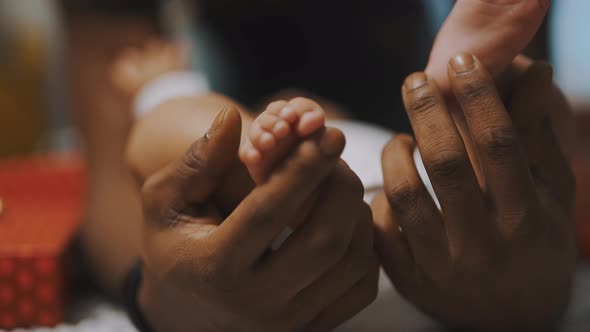 Black Father Playing with Baby Feet alt