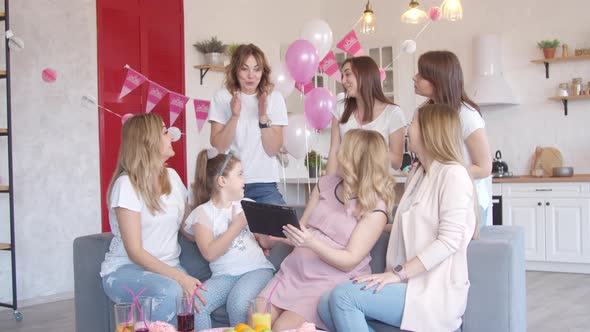 Women Looking at Tablet at Baby Shower Party