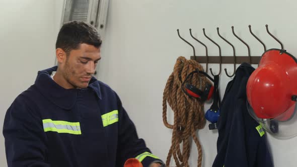 Exhausted fireman standing in the office alt