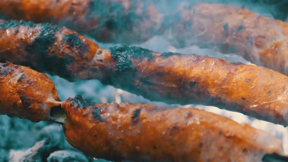Sausages on Skewers are Cooked on the Portable Grill Outdoor Close Up BBQ alt