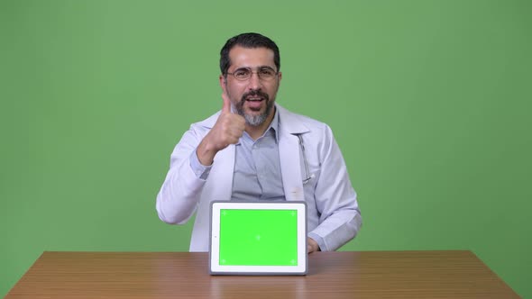 Handsome Persian Bearded Man Doctor Giving Thumbs Up While Showing Digital Tablet