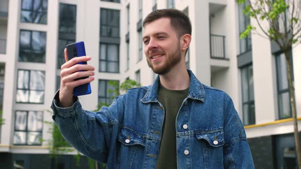 Young Man Using Mobile Phone for Video Call Outside alt