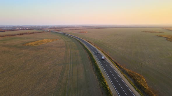 Aerial View of Intercity Road with Fast Driving Cars at Sunset alt