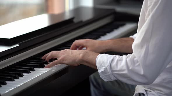 In piano lessons for adults, a pianist plays a melody on the piano. alt