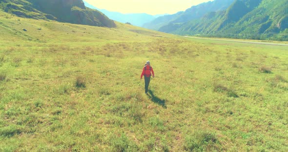 Flight Over Backpack Hiking Tourist Walking Across Green Mountain Field alt