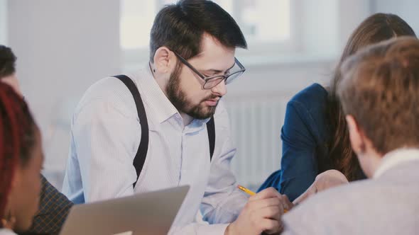 Medium Shot Portrait of Young Successful Caucasian Businessman Listening, Working Behind Modern alt