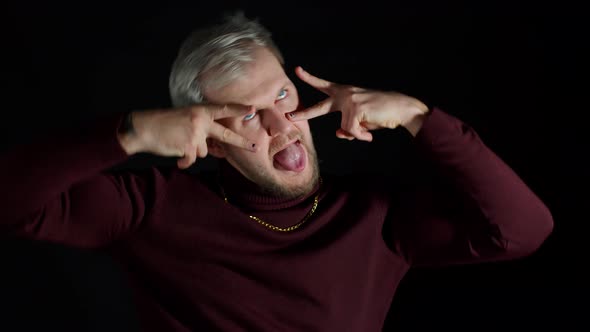 Comical Stupid Stylish Man Making Funny Silly Face Grimace Playing Fool Showing Tongue Brainless alt