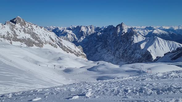 Panorama of ski resort in the german alps. Skiers on a slope on a sunny winter day.