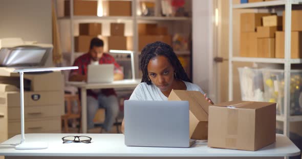 African Female Manager Check Address on Parcel Boxes Working in Warehouse alt