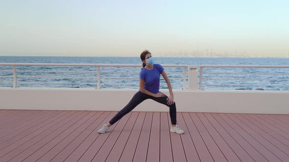 Girl Does Exercises in Front of Sea