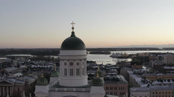 Aerial view drone flying close to the dome of Helsinki Cathedral with city and sea in background. alt