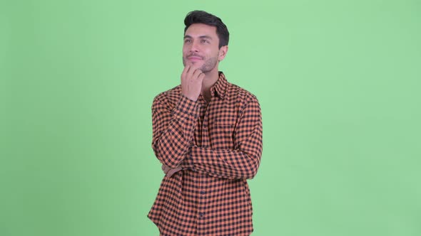 Happy Young Hispanic Hipster Man Thinking and Looking Up alt