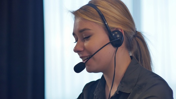 Female customer support operator with headset talking and smiling
