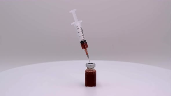 Vaccine bottle with red solution with syringe
