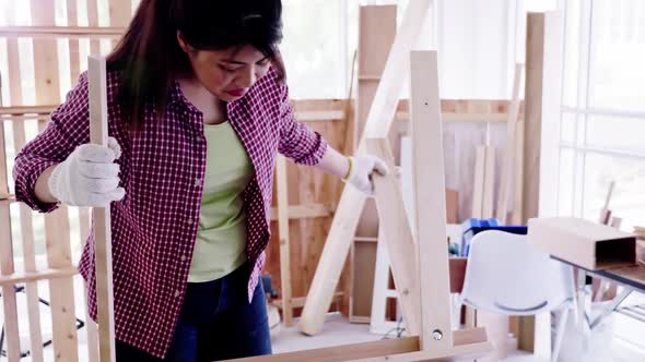 Stylish craftswoman working in carpentry. Woodwork and furniture making concept. alt