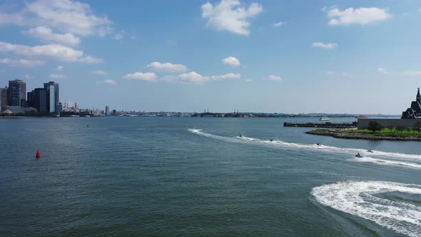 A low angle drone shot looking at several watercraft riders on the Hudson River. The drone camera do alt