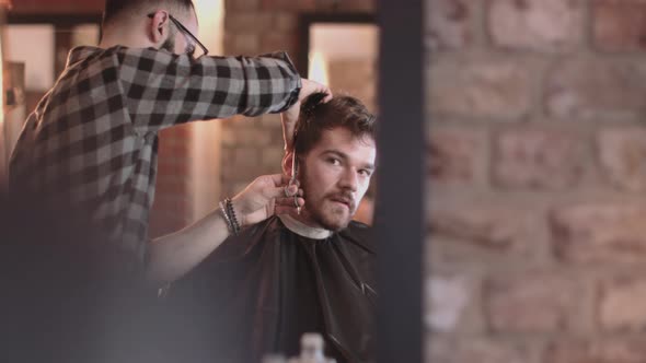 Young Adult Male having haircut in barbershop