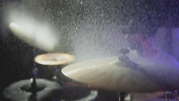 The Drummer Hits the Wet Drum Cymbal with His Drumstick and the Water Splashes in Slow Motion alt