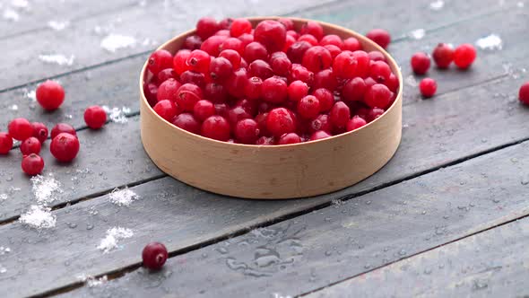 Fresh cranberries in a bowl on the table and snow